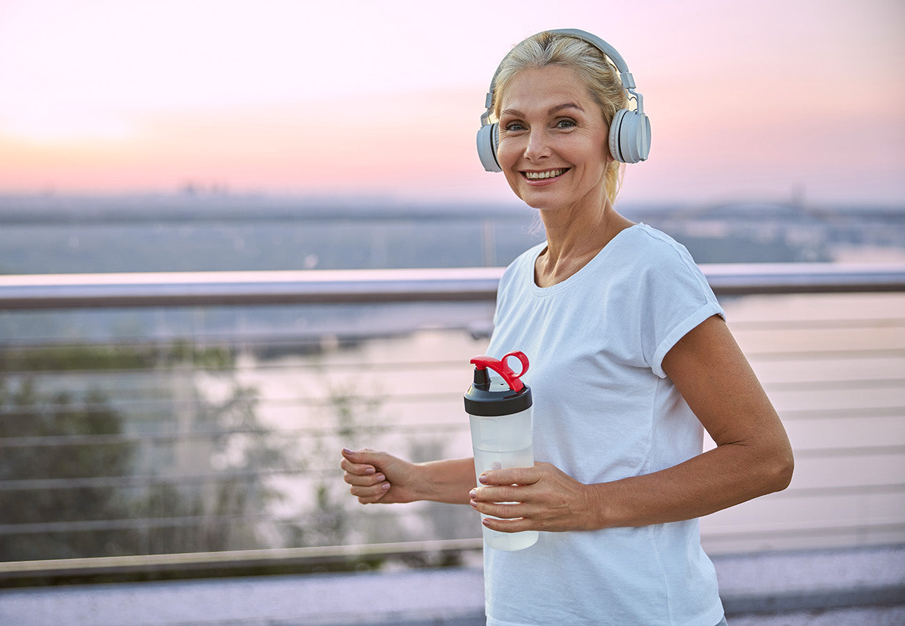 Femme mature dynamique et active en train de faire un footing, reprĂ©sentant le bien-ĂȘtre et la vitalitĂ© apportĂ©s par les complĂ©ments alimentaires Les Boosters Naturels