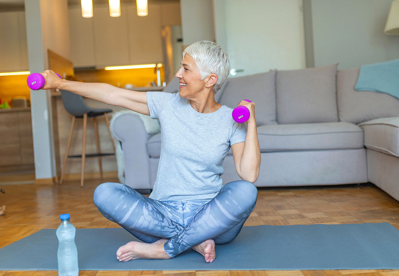 Femme mature souriante faisant du sport, illustrant les bienfaits du Booster Immunité des Boosters Naturels pour maintenir une bonne santé, renforcer les défenses immunitaires et soutenir un mode de vie actif